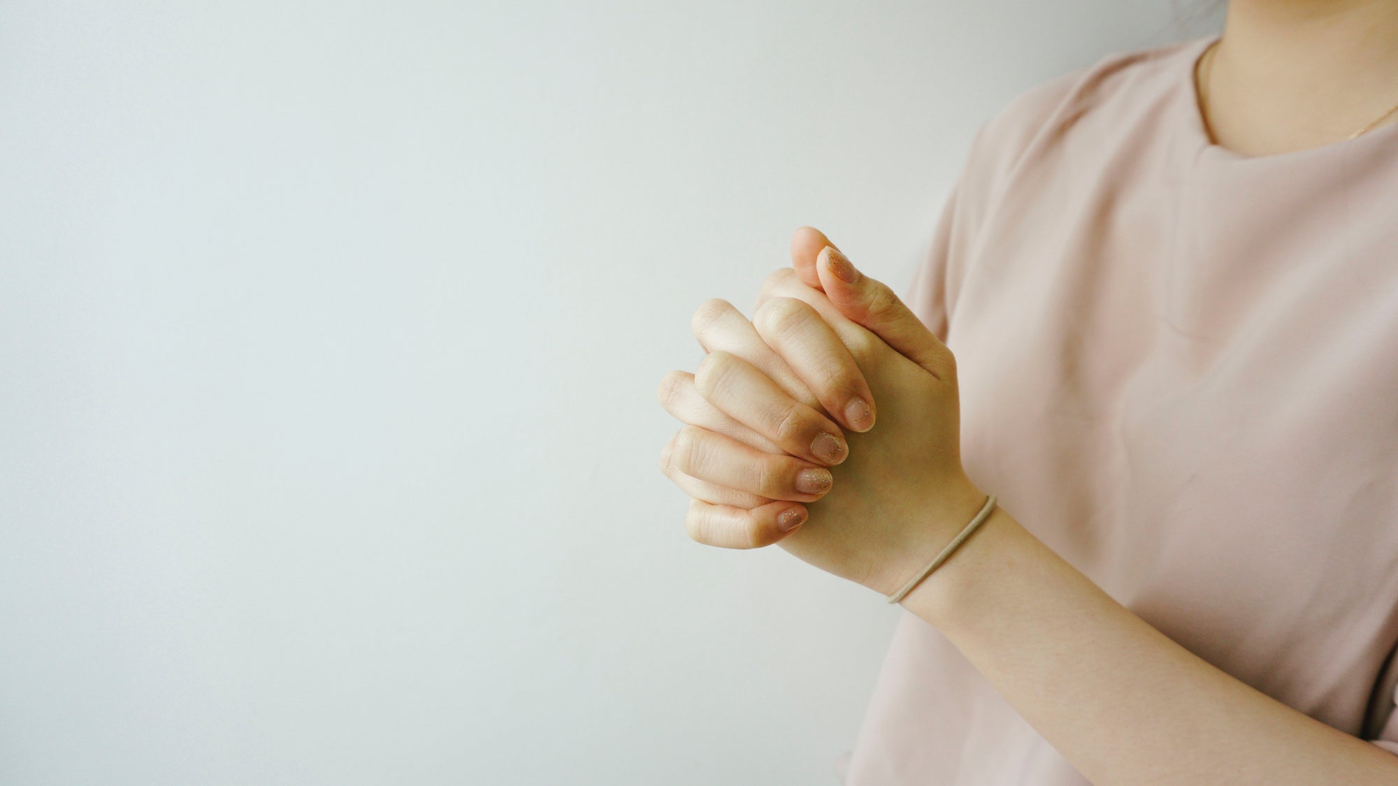 Woman wearing pink praying. 