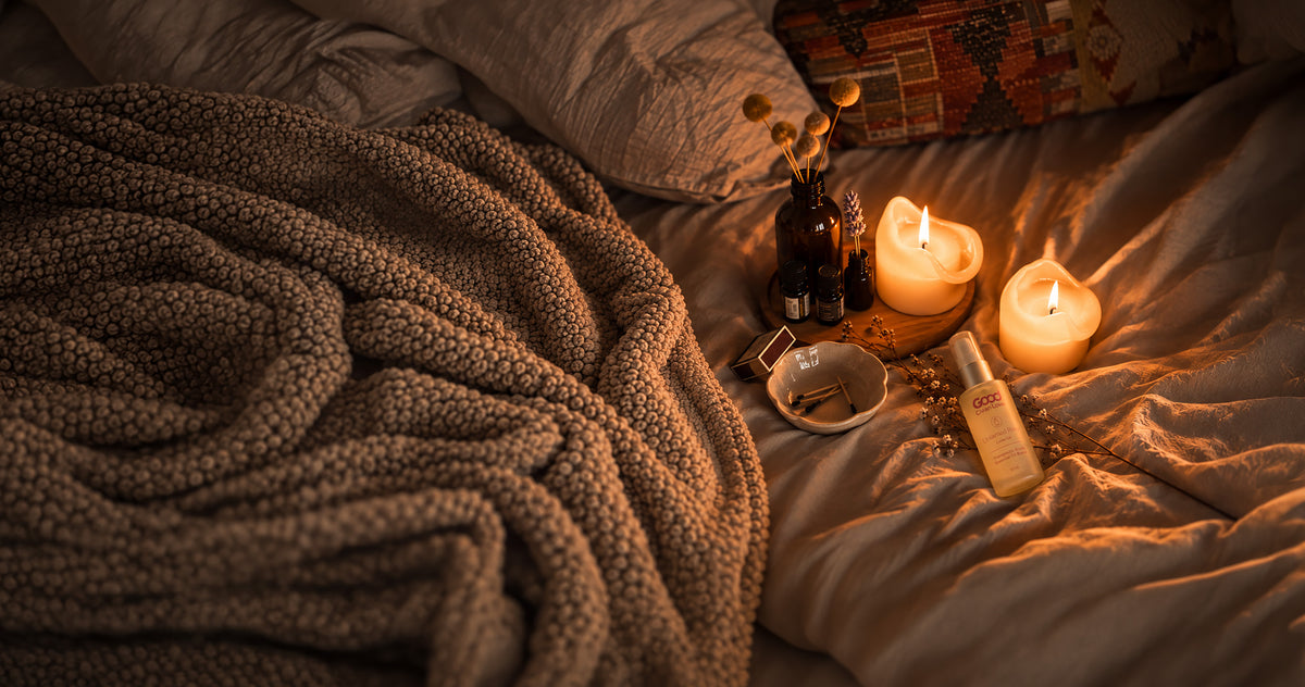 candles, matches, and love oil on bed sheets